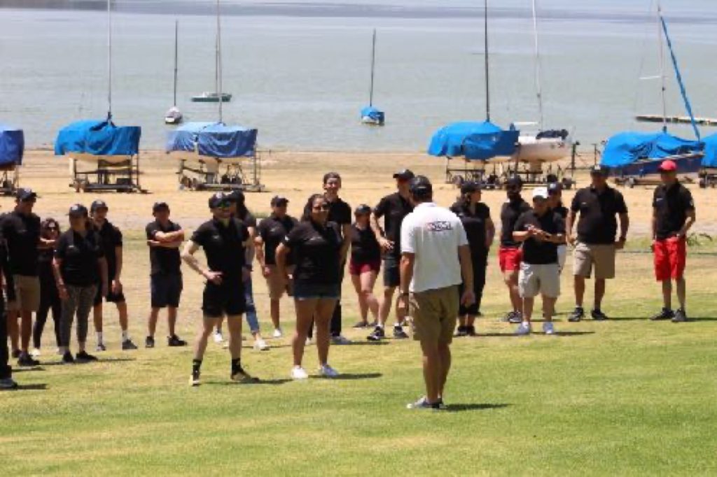 Equipo trabajando a orilla del lago durante la dinámica Build a boat