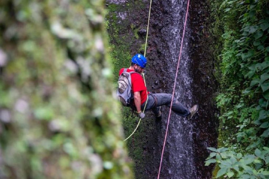Participante descendiendo en rapel por una pared de roca en Valle de Bravo