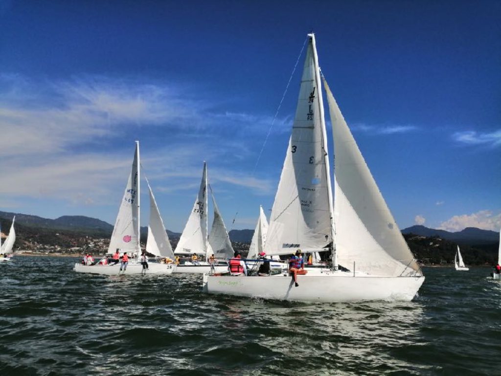 Veleros compitiendo en el lago de Valle de Bravo durante la regata de team building